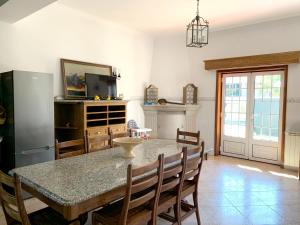 a dining room with a table and chairs and a refrigerator at 9 bedrooms villa with private pool jacuzzi and enclosed garden at Ponte de Lima Viana do Castelo in Ponte de Lima