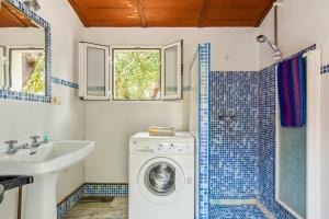 ein Badezimmer mit einer Waschmaschine und einem Waschbecken in der Unterkunft 4 bedrooms villa with private pool and enclosed garden at Cortegana in Cortegana