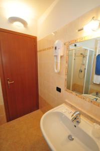 W łazience znajduje się umywalka, lustro i prysznic. w obiekcie Locanda Sant'Anna Hotel w Wenecji