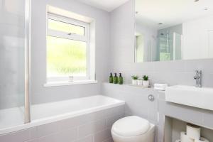 a white bathroom with a toilet and a sink at 2 bed house close to Town Centre in Bracknell