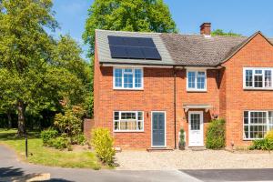 a red brick house with solar panels on the roof at 2 bed house close to Town Centre in Bracknell +5 photos