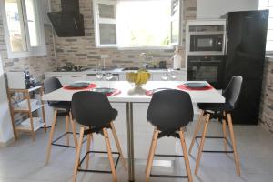 une cuisine avec une table blanche et quatre chaises dans l'établissement Maison de 2 chambres avec vue sur la ville jacuzzi et jardin amenage a Riviere Salee, à Rivière-Salée