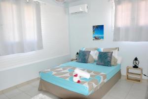 - une chambre avec un lit bleu dans l'établissement Maison de 2 chambres avec vue sur la ville jacuzzi et jardin amenage a Riviere Salee, à Rivière-Salée