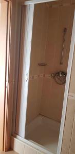 a shower with a glass door in a bathroom at Modern house in Altura with terrace and city view in Altura