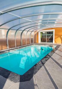 una piscina en un edificio con techo de cristal en Appartement moderne avec piscine à Plan-d'Aups 55 m² - Spa inclus​, en Plan dʼAups