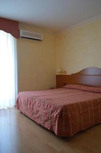 una camera con un letto e una coperta rosa di Hotel Parco Serrone a Corato