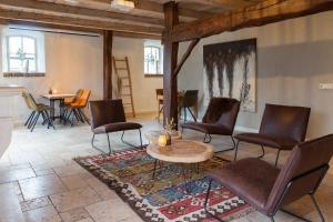 a living room with chairs and a table and a table at Brabantse Hoeve in Volkel