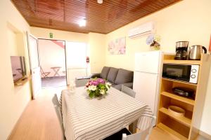 a kitchen and dining room with a table with flowers on it at 2 bedrooms apartement with shared pool furnished terrace and wifi at Prazeres 5 km away from the beach in Campanário
