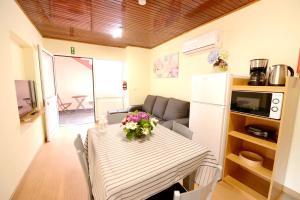 a kitchen and dining room with a table with flowers on it at Modern apartment in Prazeres with shared pool, 150 m² in Campanário