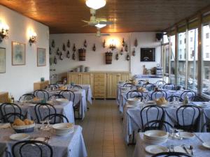 a room with tables and chairs in a restaurant at Hotel Nettuno in Diano Marina