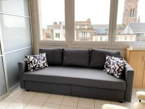 a couch sitting in a room with windows at One bedroom appartement at Blankenberge 200 m away from the beach with city view and wifi in Blankenberge