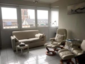 a living room with a couch and chairs and windows at One bedroom appartement at Blankenberge 200 m away from the beach with city view and wifi in Blankenberge