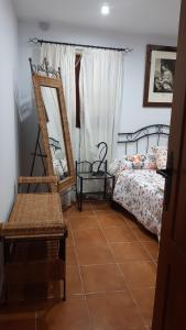 1 dormitorio con cama, espejo y silla en Casa Rural Fray Eloy, en Guadalupe