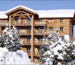 a large apartment building with a deck in the snow at Appartement confortable à Les Deux Alpes 45 m² avec vue montagne in Mont-de-Lans