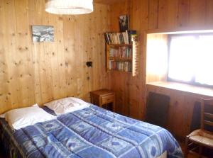 ein Schlafzimmer mit einem Bett in einer Holzwand in der Unterkunft Maison de 2 chambres a Notre Dame de Bellecombe a 100 m des pistes avec jardin amenage et wifi in Notre-Dame-de-Bellecombe