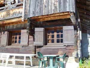 una mesa y sillas fuera de una cabaña de madera en Maison de 2 chambres a Notre Dame de Bellecombe a 100 m des pistes avec jardin amenage et wifi en Notre-Dame-de-Bellecombe