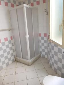 Un baño con paredes a cuadros y una cabina de ducha. en Spacious House in Mazara del Vallo, en Mazara del Vallo