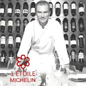ジュネーヴにあるロイヤル マノテルのワインの瓶棚前に立つ料理人