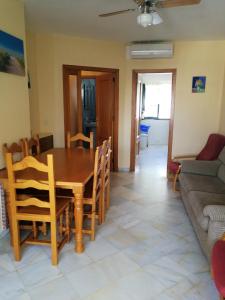 comedor y sala de estar con mesa y sillas en 3 bedrooms apartement with city view shared pool and terrace at El Portil 1 km away from the beach, en El Portil