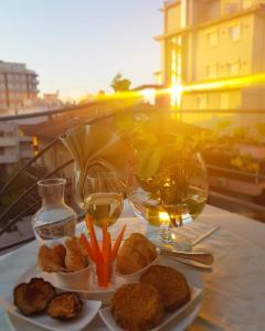 una mesa con platos de comida y copas de vino en HOTEL ROMANTICA, en Rímini