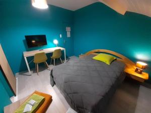 Schlafzimmer mit einem Bett, einem Schreibtisch und einem TV in der Unterkunft L Etoile d'Argent in Varangéville
