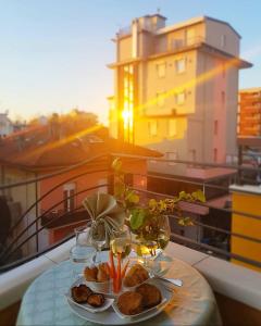 リミニにあるHOTEL ROMANTICAのバルコニーにテーブルと食器