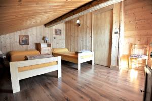 シャンパニー・アン・ヴァノワーズにあるAppartement de 4 chambres a Champagny en Vanoise a 400 m des pistes avec jardin clos et wifiの木製の壁の客室で、ベッド2台が備わります。