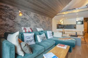 a living room with a blue couch and a table at Appartement spacieux L'Alpe d'Huez, balcon in LʼHuez +22 photos