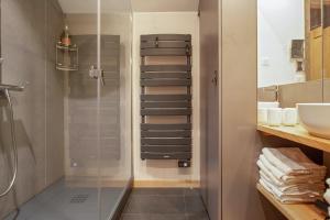 a bathroom with a shower and a glass shower stall at Appartement spacieux L'Alpe d'Huez, balcon in LʼHuez