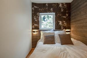 a bedroom with a bed with two pillows and a window at Appartement spacieux L'Alpe d'Huez, balcon in LʼHuez
