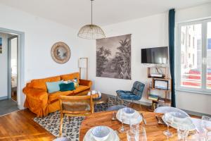 a living room with a couch and a table at Le Zénith - avec vue mer in Saint Malo