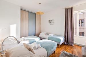 a room with three beds and a couch at Le Zénith - avec vue mer in Saint Malo
