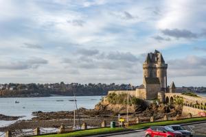 un château situé sur une colline à côté d'une étendue d'eau dans l'établissement Le Zénith - avec vue mer, à Saint-Malo