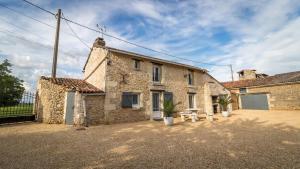 a stone building with two potted plants in front of it at Maison de charme à Arçay avec jacuzzi in Arçay