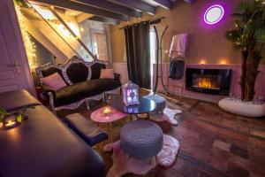 a living room with a couch and a fireplace at Maison de charme à Arçay avec jacuzzi in Arçay