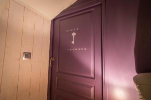a purple door with a key on it in a room at Maison de charme à Arçay avec jacuzzi in Arçay +12 photos