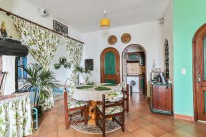 a dining room with a table and a kitchen at Studio en bord de mer à Menton avec piscine privée 80 m² in Menton