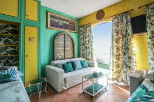 a living room with a couch and a table at Studio en bord de mer à Menton avec piscine privée 80 m² in Menton