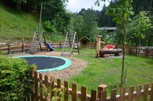 patio trasero con parque infantil con tobogán y columpio en Gasthof Zum Lendwirt, en Westendorf