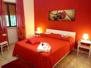 una camera rossa con due letti e due lampade di Charming House in Melissano a Melissano