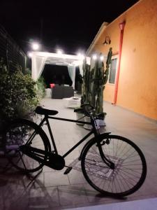 una bicicletta parcheggiata di fronte a una casa di notte di Charming House in Melissano a Melissano