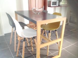 a wooden table with four chairs and a glass bowl on top at Appartement de 2 chambres avec balcon et wifi a Les Abymes a 7 km de la plage in Les Abymes
