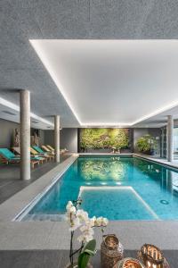 a large swimming pool in a building at Hôtel WELLNESS EAU DE ROCHE Durbuy in Durbuy