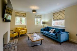 sala de estar con sofá azul y mesa en Sloley Hall Cottages - Stable 1 en Tunstead