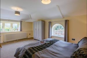 ein Schlafzimmer mit einem großen Bett und einem Fenster in der Unterkunft Sloley Hall Cottages - Stable 1 in Tunstead