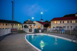 a swimming pool in front of a building at night at Days Inn by Wyndham Osage Beach Lake of the Ozarks in Osage Beach