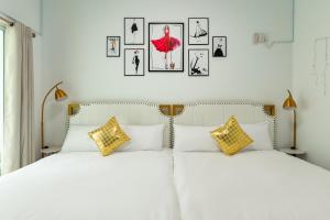 2 letti in una camera da letto con immagini appese al muro di W Homestay a Magong