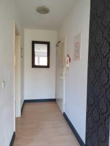 un pasillo vacío con una puerta y un espejo en CityPark Aparthotel en Colonia