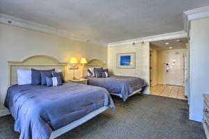 a hotel room with two beds and a bathroom at 10th-Floor Studio on Beach - Walk to Area Dining! in Daytona Beach