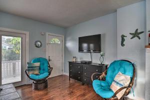 a living room with two chairs and a tv at Condo with Community Pool - Walk to Madeira Beach! in St Pete Beach